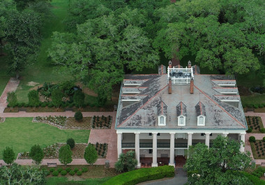 a large brick building with grass and trees