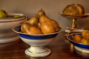 a bowl of fruit sitting on top of a wooden table